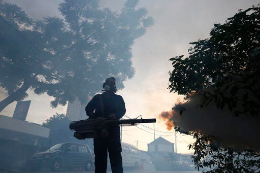 FILE - In this Wednesday, Sept. 14, 2016 file photo, a worker from the Ministry of Health sprays mosquito insecticide fog in Kuala Lumpur, Malaysia, a day after two new Zika virus infection cases were detected in the country. On Thursday, Sept. 29, 2016, U.S. health officials are advising pregnant women to postpone travel to 11 countries in Southeast Asia because of Zika outbreaks in the region. The advisory targets travel to Brunei, Cambodia, East Timor, Indonesia, Laos, Malaysia, the Maldives, Myanmar, the Philippines, Thailand and Vietnam. (AP Photo/Joshua Paul)