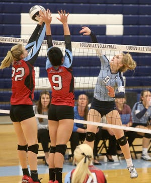 Alliance's Mary Zurbrugg (22) and Channing Thomas (9) try to block the shot of Louisville's Sarah Lairson (9) at Thursday's game in Louisville. (CantonRep.com/Scott Heckel)