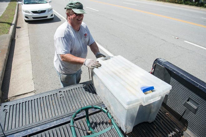 Tybee Island City Councilman Monty Parks shoves a container of trash into the back of his truck after cleaning up a section of marshland of the coast of Tybee Wednesday. (Josh Galemore/Savannah Morning News)