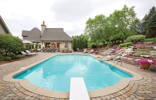 This lavish outdoor kitchen and swimming area in Tartan Fields allows its homeowners to enjoy summertime at its best. The tranquil setting, including its tiered garden, was perfectly planned for the 740-square-foot saltwater swimming pool.