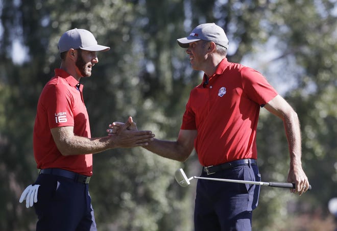 Dustin Johnson, left, and Matt Kuchar of the United States celebrate after winning their foursomes match 5 & 4 on Friday. The Associated Press
