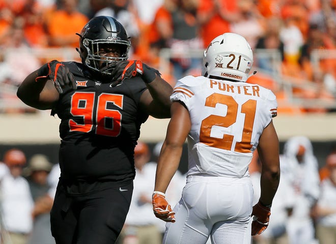 Oklahoma State's Vincent Taylor (96) celebrates a defensive stop next to Texas's Kyle Porter (21) during a college football game between the Oklahoma State University Cowboys (OSU) and the Texas Longhorns (UT) at Boone Pickens Stadium in Stillwater, Okla., Saturday, Oct. 1, 2016. Photo by Sarah Phipps, The Oklahoman