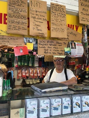 Jack Gilmore with his paper bag-backed notes to customers in his business, Crazy Jack's Shoe Repair. (Photo by Jane Fishman/For Savannah Morning News)