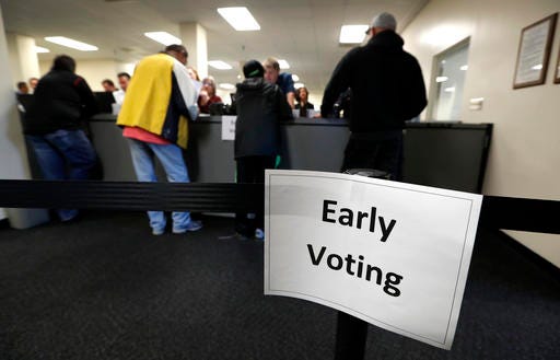 Residents receive their ballots at the Polk County Election Office on the first day of early voting in Des Moines, Iowa. Many Americans have at least some doubts about votes in this year's presidential election will be counted accurately, and a significant number are concerned about the possibility of interference in the election by foreign hackers.