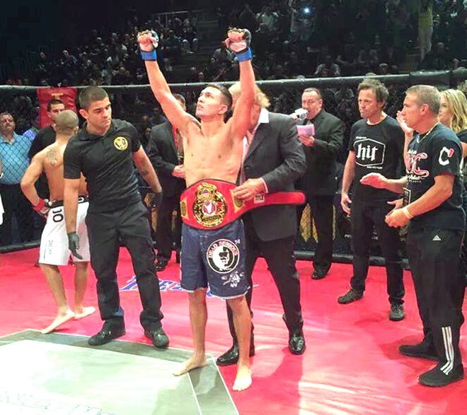 Levittown's Matt Rizzo is shown receiving his Ring Of Combat flyweight championship belt in September of 2014. Rizzo will be fighting on the Fox Sports 1 series "The Ultimate Fighter 24" on Wednesday night at 10 p.m.