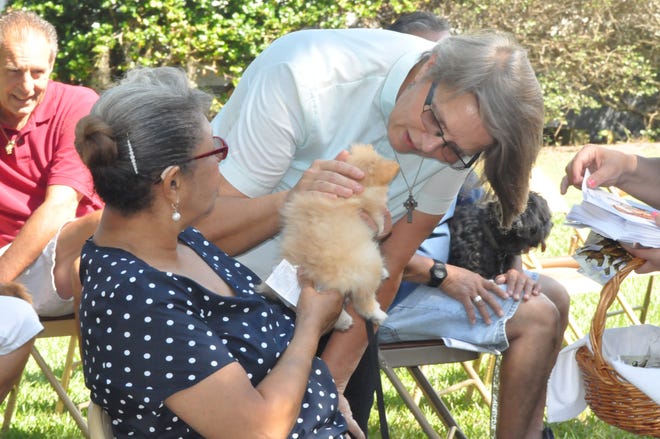 Sucy the Pomeranian, held by Barbara Norelli, is blessed by the Rev. Amanda Bordenkircher on Saturday at St. Matthias Episcopal Church in Clermont. (Photos by Linda Charlton / Correspondent)