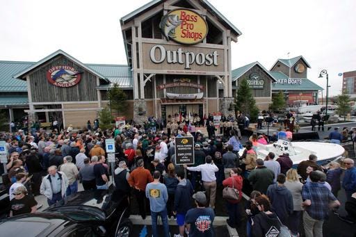 FILE - In this Wednesday, April 15, 2015, file photo, a large crowd of people line up as they wait for the grand opening of Bass Pro Shops Outpost store in Atlantic City, N.J. Outdoor gear giants Bass Pro and Cabela's will combine in a $4.5 billion deal announced Monday, Oct. 3, 2016. (AP Photo/Mel Evans, File)
