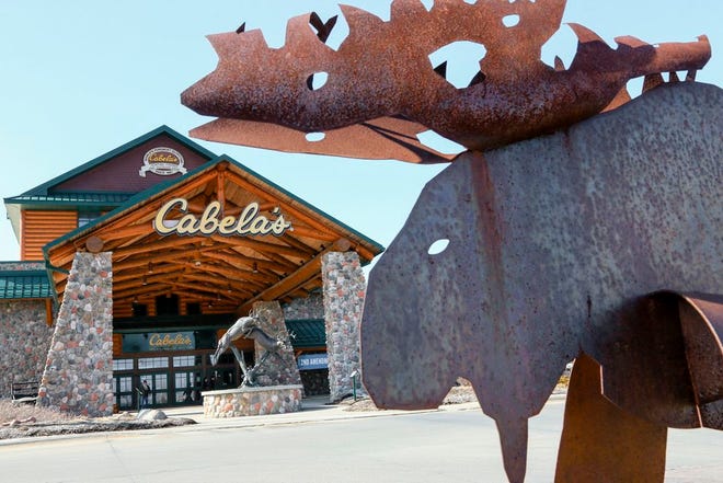 Statues of wildlife adorn the entrance to a Cabela's store on Feb. 17, 2016 in LaVista, Neb. Outdoor gear giants Bass Pro and Cabela's will combine in a $4.5 billion deal announced Monday, Oct. 3, 2016.