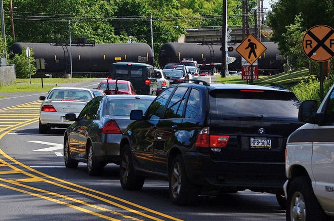 (File) Drivers wait for a CSX train at Woodbourne Road in Middletown in September 2014. The delays have lasted up to two hours as train cars are attached and detached at a nearby rail yard.