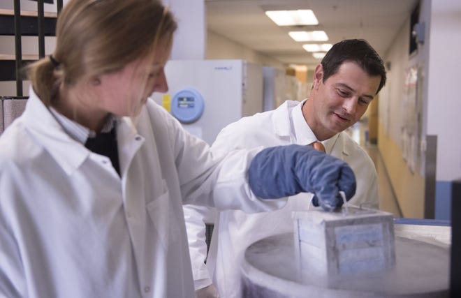 Associate Professor and Director of Academic Affairs at the Baruch S. Blumberg Institute John Kulp (right) has been named an Emerging Leader. Kulp is seen here checking cell lines in a cryogenic freezer in the lab with post baccalaureate apprentice Lexi Caldwell (left) in Doylestown Township.