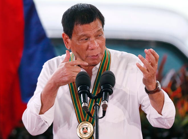 Philippine President Rodrigo Duterte gestures with a firing stance as he announces issuing side arms to army troopers during his visit to its headquarters in suburban Taguig city east of Manila, Philippines Tuesday Oct. 4, 2016. U.S. and Philippine forces opened their first large scale combat exercises under President Duterte in uncertainty Tuesday after he said the drills will be the last in his six-year presidency partly to avoid upsetting China.(AP Photo/Bullit Marquez)