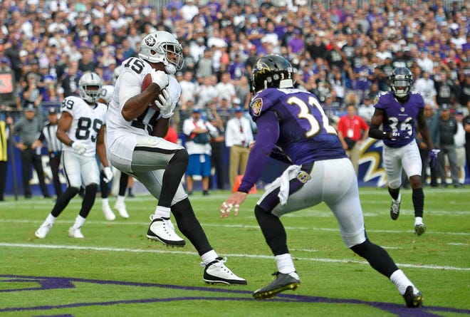 Oakland Raiders wide receiver Michael Crabtree, left, makes a touchdown catch in front of Baltimore Ravens strong safety Eric Weddle in the second half of an NFL football game, Sunday, Oct. 2, 2016, in Baltimore. (AP Photo/Nick Wass)