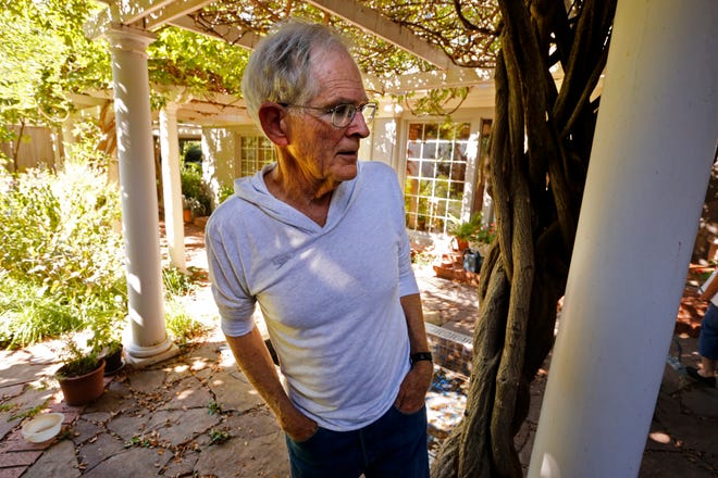 Charles Wesner stands near a pergola on the patio of his Southridge Addition home in east Norman. The house is an example of a 1930s-era California bungalow.