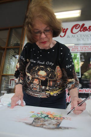 Darlene Godfrey paints in watercolor at her booth during Art Walk in Uptown Thursday afternoon. (Hannah Covington/ The Star)