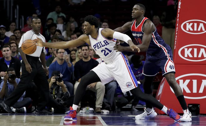 Sixers center Joel Embiid (21) reaches for the ball as the Wizards' Ian Mahinmi defends during the first half of Thursday's preseason game at the Wells Fargo Center. (AP Photo/Matt Slocum)