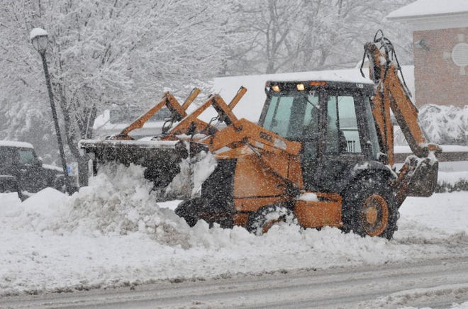 A construction vehicle clears snow on Street Road near the Upper Southampton Township Police Department on Feb. 2, 2014.