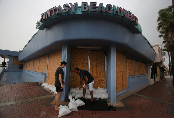 Miroslava Ronovjakova and Ray Hayyat places sandbags in front of their Main St business as Hurricane Matthew approaches , Thursday, Oct. 6, 2016. News-Journal/NIGEL COOK