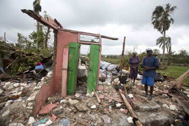 Saintanor Dutervil stands with his wife in the ruins of their home destroyed by Hurricane Matthew in Les Cayes, Haiti, Thursday, Oct. 6, 2016. Two days after the storm rampaged across the country's remote southwestern peninsula, authorities and aid workers still lack a clear picture of what they fear is the country's biggest disaster in years. (AP Photo/Dieu Nalio Chery)