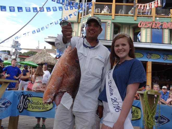 Dave Martine shows off a head of a black snapper that he hooked and reeled in while fishing aboard the Destin Princess with Capt. Reid Phillips. The head weighed in at 7.6 pounds and was big enough to make the daily leader board in the Destin Fishing Rodeo. Wishing him well is Miss Destin Sydney Curry. TINA HARBUCK/THE LOG