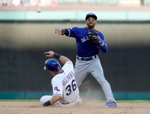 Toronto Blue Jays second baseman Devon Travis throws to first for the double play after forcing out Texas Rangers' Carlos Beltran during the seventh inning of Game 1 baseball's American League Division Series, Thursday, Oct. 6, 2016, in Arlington, Texas. Adrian Beltre was out at first. (AP Photo/David J. Phillip)