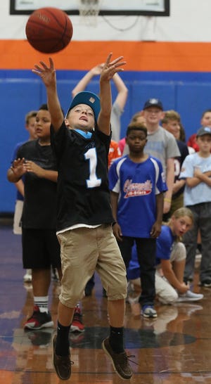 Sixth grader Landon Hahn, 11, attempts a half-court shot during a fundraiser at Chavis Middle School on Friday afternoon for the late Cherryville High School student Noah Hampton. PHOTO MIKE HENSDILL/THE GAZETTE