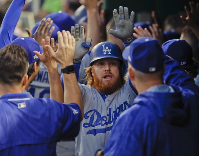 Los Angeles Dodgers' Justin Turner is greeted in the dugout after hitting a two-run home run off Nationals starting pitcher Max Scherzer during the third inning on Friday night in Washington. The Associated Press