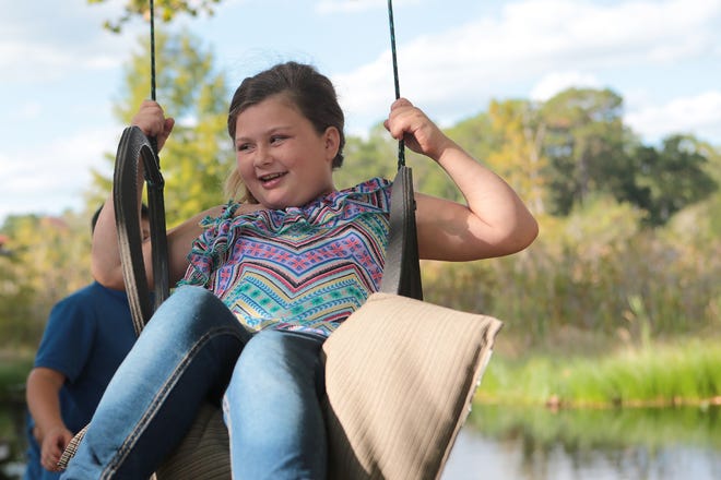 Zoey Castro, 9, swings with her brothers in her backyard on Wednesday. Zoey and her family recently learned that she has two holes in her heart requiring open-heart surgery. HEATHER HOWARD/The News Herald