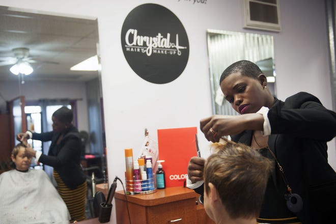 Chrystal Sadler cuts Robin Johnson’s hair Thursday at her salon, Chrystal L. Hair & Makeup. Sadler opened her salon in January.
