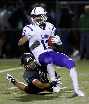 South Eugene's Myles Green-Richards is tackled by Sheldon's Orin Patu while fielding a punt in the third quarter of the Irish's matchup with the Axemen at Sheldon. (Andy Nelson/The Register-Guard)