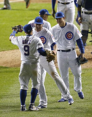 Javier Baez (9) celebrates with his teammates afterthe Cubs won Game 1 against the San Francisco Giants on Friday night in Chicago. Baez's home run in the eighth was the only run in the game. The Associated Press