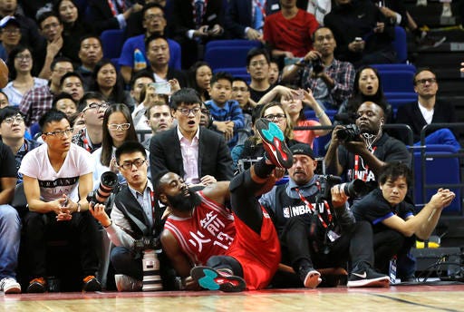 Houston Rockets James Harden falls into the crowd during their preseason NBA game against the New Orleans Pelicans in Shanghai, China, Sunday, October, 9, 2016. (AP Photo)