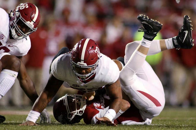 Alabama's Ryan Anderson falls on top of Arkansas quarterback Austin Allen, after Allen was sacked by Alabama's Tim Williams, left. No. 1 Alabama defeated the Razorbacks, 49-30, on Saturday in Fayetteville, Ark.