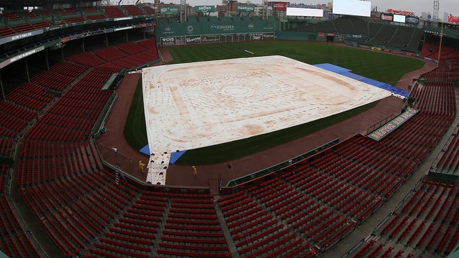 A photo tweeted by MLB shows a tarp over Fenway Park, in Boston, Sunday, Oct. 9, 2016.