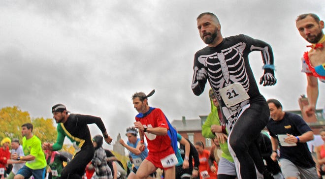 Runners are off in the first leg of the	13th running of the Grog and Dog Jog in Providence, in which 90 teams of four run in costumes for charity. The Providence Journal / David DelPoio
