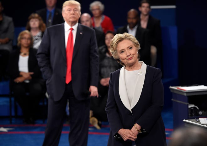 Democratic presidential nominee Hillary Clinton, right, and Republican presidential nominee Donald Trump listen to a question during the second presidential debate at Washington University in St. Louis, Sunday, Oct. 9, 2016. (Saul Loeb/Pool via AP)