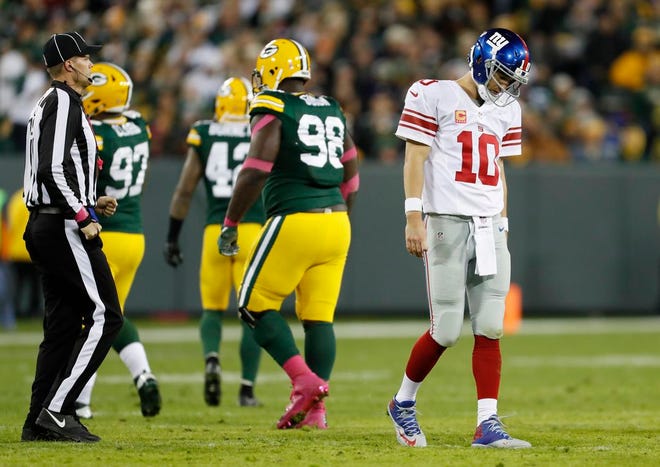 Giants' Eli Manning walks off the field after an incomplete pass during the second half against the Packers.