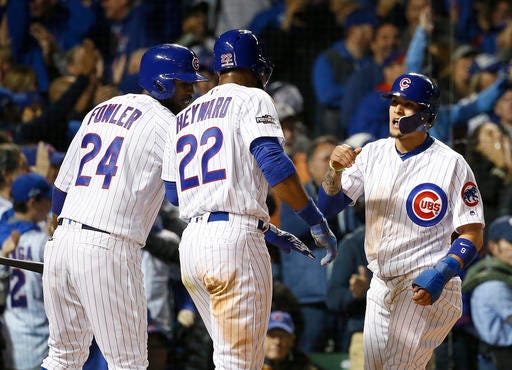 Chicago Cubs' Javier Baez celebrates with Dexter Fowler (24) and Jason Heyward (22) after sliding safely into home after a single by Kyle Hendricks in the second inning of Game 2 of baseball's National League Division Series, Saturday, Oct. 8, 2016, in Chicago. (AP Photo/Nam Y. Huh)
