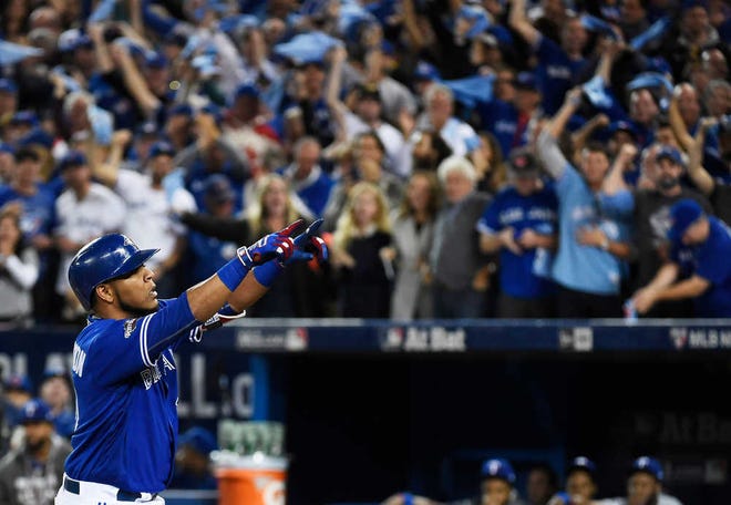Toronto Blue Jays' Edwin Encarnacion (10) celebrates his two-run home run against the Texas Rangers during first inning American League Division Series baseball action in Toronto on Sunday, Oct. 9, 2016. (Nathan Denette/The Canadian Press via AP)