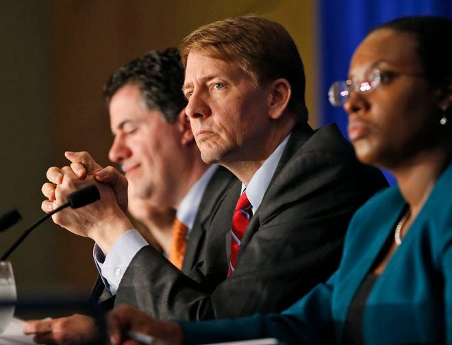 Consumer Financial Protection Bureau Director Richard Cordray, center, listens to comments during a panel discussion on March 26, 2015 in Richmond, Va. On Tuesday, Oct. 11, 2016, a federal appeals court ruled that the way the CFPB is organized violates the Constitution's separation of powers by limiting the president's ability to remove the director who heads the agency. Cordray, a Democrat and former Ohio attorney general, has run the agency since it began operating in July 2011.