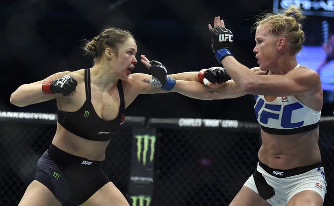 FILE - In this Nov. 15, 2015, file photo, Ronda Rousey, left, and Holly Holm fight during their UFC 193 bantamweight title bout in Melbourne, Australia. Rousey will return to the UFC on Dec. 30 in Las Vegas, fighting Amanda Nunes for the bantamweight title. (AP Photo/Andy Brownbill)