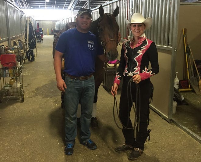 Alexis native Rachel Munday, right, poses with her husband Eric Munday. Recently, the 28-year-old Munday took first place out of 68 total contestants in the Green Reiner category of the American Quarter Horse Congress competition in Columbus, Ohio.