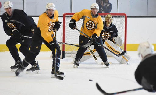 Boston Bruins defenseman Zdeno Chara, left, starts to drop his stick on a shot to goalie Tuukka Rask, right, during an NHL hockey practice in Boston, Tuesday, Oct. 11, 2016. At right is left wing Brad Marchand. From left are Chara, center Patrice Bergeron, left wing Brad Marchand and Rask. (Faith Ninivaggi/The Boston Herald via AP)