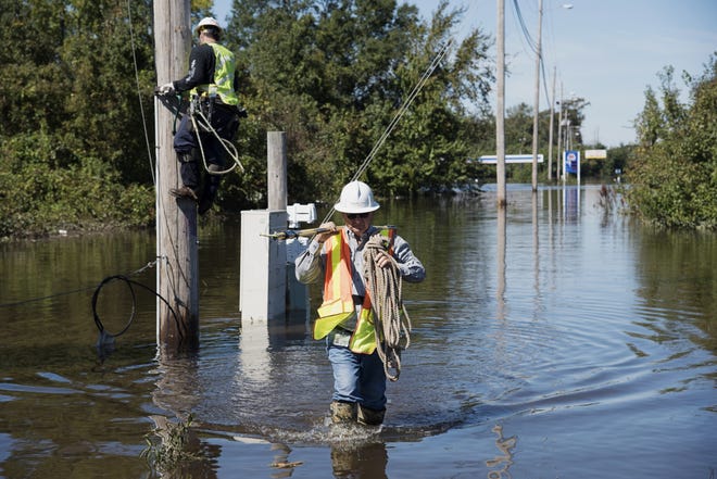 A lineman works to restore power lines near I-95 after the area was flooded by rain from Hurricane Matthew in Lumberton, N.C., Tuesday, Oct. 11, 2016. (AP Photo/Mike Spencer)