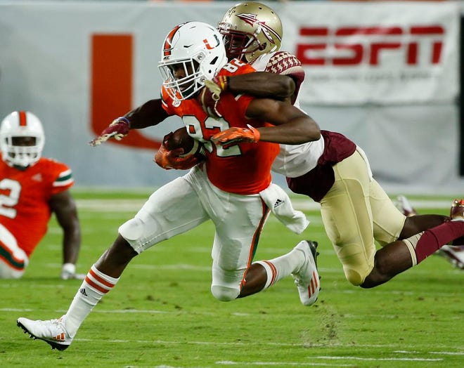 Florida State defensive back Tarvarus McFadden (4) tackles Miami wide receiver Ahmmon Richards (82) during the first half of a game, Saturday in Miami Garden.