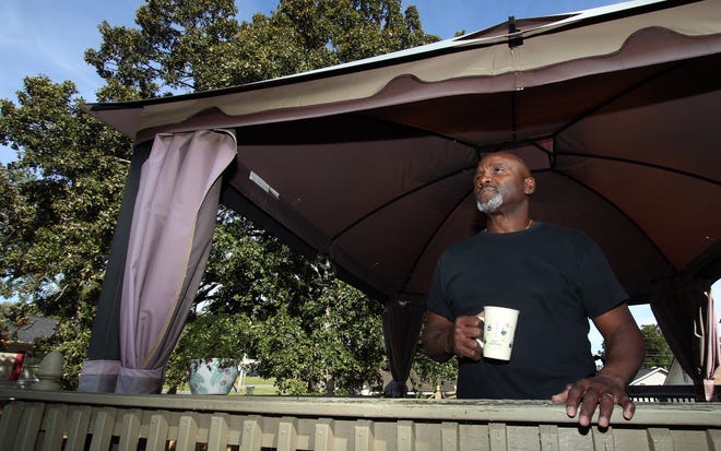 Marvin Glenn has a cup of coffee on the back porch of his home on North Pryor Street Tuesday morning. The smell from nearby Porta-Jon business has neighbors complaining. PHOTO MIKE HENSDILL/THE GAZETTE