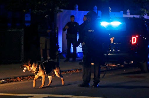 Police search for a suspect after a shooting in the East Boston neighborhood of Boston, Wednesday, Oct. 12, 2016. Police say two officers were shot late Wednesday night. Their conditions were not immediately available. It's unclear what led to the shooting. (AP Photo/Charles Krupa)
