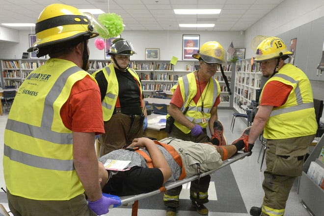 Coates Bend firefighters remove a "victim" from the media center during an active shooter exercise Thursday at Gaston High School north of Gadsden. (Marc Golden/ Gadsden Times)