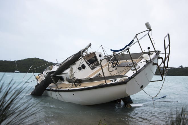 A sailboat lays damaged on the shore of Ferry Reach after breaking free from its mooring after the passing of Hurricane Nicole in St. Georges, Bermuda, Thursday, Oct. 13, 2016. Nicole pummeled the resort island as a Category 3 storm with winds that snapped trees and peeled off roofs before it spun away into open water as a Category 1 storm. (AP Photo/Mark Tatem)