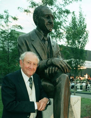 Morris J.W. Gaebe next to a statue of him at Johnson & Wales campus in Providence in 1998. The Providence Journal/Ruben W. Perez