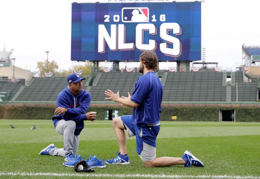 Los Angeles Dodgers manager Dave Roberts, left, talks to Clayton Kershaw as players warm up before Game 1 of baseball's National League Championship Series against the Chicago Cubs, Saturday, Oct. 15, 2016, in Chicago. (AP Photo/Morry Gash)